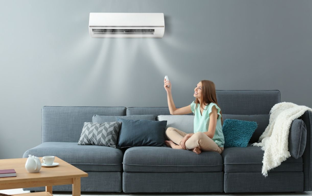 Wall-mounted split system air conditioner in a living room, operated by remote
